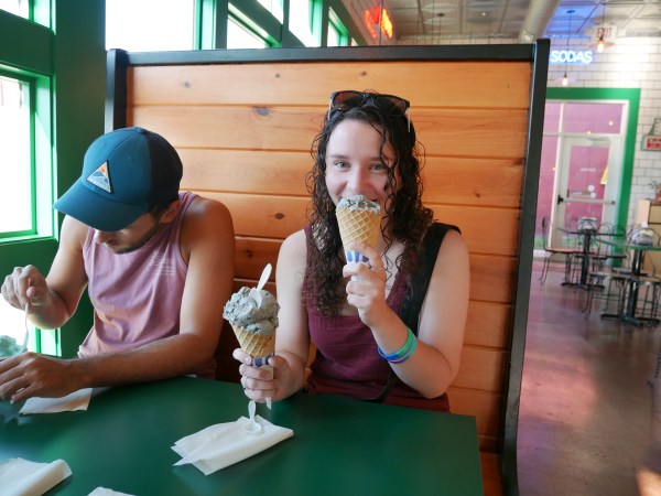 Young woman eating an ice cream cone in a booth at Ted & Wally's.